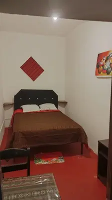 a bedroom with a bed in a white room at 7 Borreguitos GUESTHOUSE in Cusco