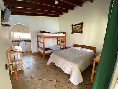 a bedroom with a bunk bed and a kitchen at QPÑ Hoteles - Hacienda Nieve Nieve in Balconcillo de Aviyay