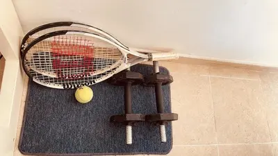 a tennis racket and a tennis ball on a rug at Cómodo e independiente minidepartamento a pasos del Circuito Mágico in Lima