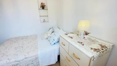 a bedroom with a bed and a dresser with a lamp at Cómodo e independiente minidepartamento a pasos del Circuito Mágico in Lima