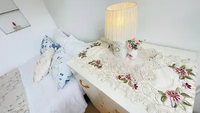 a bed with a table with a lamp on it at Cómodo e independiente minidepartamento a pasos del Circuito Mágico in Lima