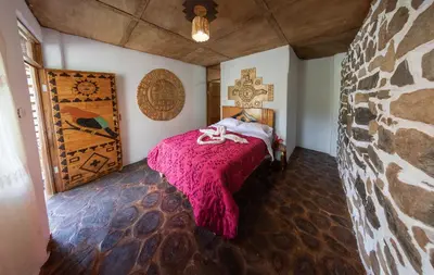 a bedroom with a bed with a pink blanket at Viamonte EcoLodge in Santa Teresa