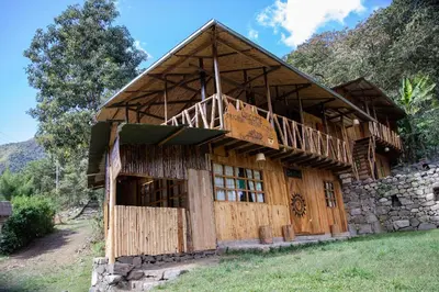 a large wooden building in the middle of a field at Viamonte EcoLodge in Santa Teresa