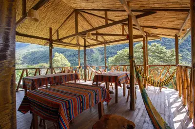 a room with two tables and a hammock in a building at Viamonte EcoLodge in Santa Teresa