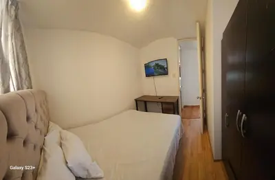 a small bedroom with a bed and a table at An apartment with an ocean view, near the airport in Lima