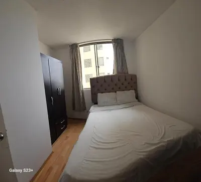 a small bedroom with a bed and a window at An apartment with an ocean view, near the airport in Lima