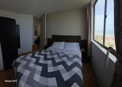 a bedroom with a bed with a large window at An apartment with an ocean view, near the airport in Lima
