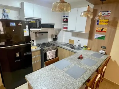 a kitchen with a black refrigerator and a counter top at Céntrico departamento in Lima