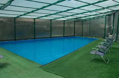 a large swimming pool with chairs in a building at Lofts Illawasi in Urubamba