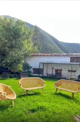 three benches sitting in the grass in front of a building at Lofts Illawasi in Urubamba