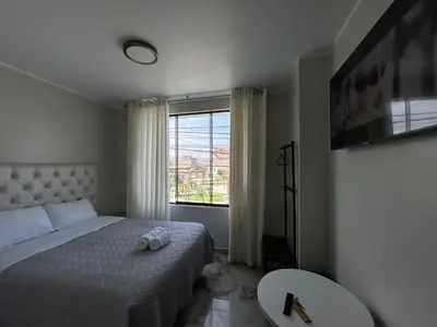 a bedroom with a bed and a large window at Nayarak Paracas in Paracas