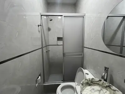 a bathroom with a toilet and a glass shower at Nayarak Paracas in Paracas