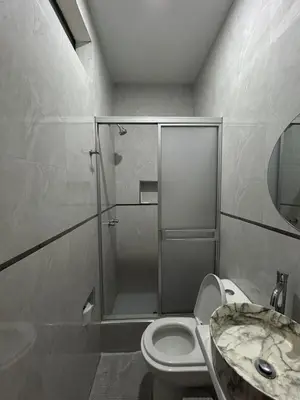 a bathroom with a shower and a toilet and a sink at Nayarak Paracas in Paracas