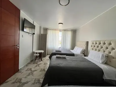 a hotel room with two beds and a table at Nayarak Paracas in Paracas