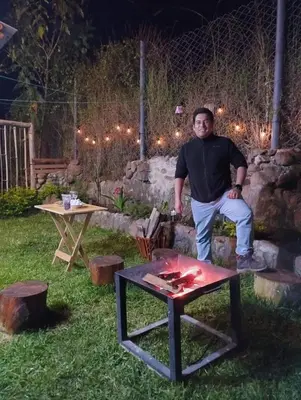 a man sitting on a table in a yard at Sweet Home Oxapampa in Oxapampa