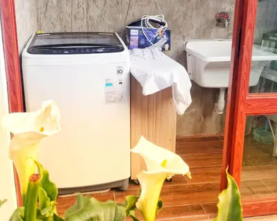 a washing machine is sitting next to a sink at Sweet Home Oxapampa in Oxapampa