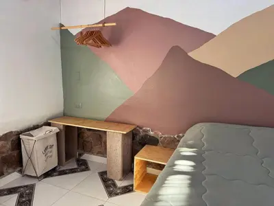 a bedroom with a mountain mural on the wall at Casa Muyuna in Calca