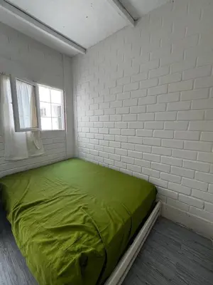 a white room with a green bed in it at Casa playa Punta Hermosa in Punta Hermosa