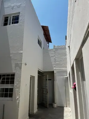 a white building with a hallway leading to a doorway at Casa playa Punta Hermosa in Punta Hermosa