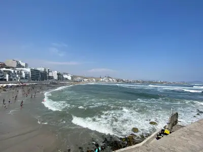 a beach with a group of people and the ocean at Casa playa Punta Hermosa in Punta Hermosa