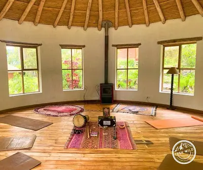 a large room with mats on the floor and windows at Hanaq Pacha Wasi in Calca