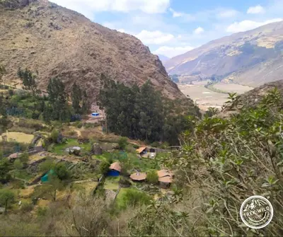 a small village on a hill with mountains in the background at Hanaq Pacha Wasi in Calca