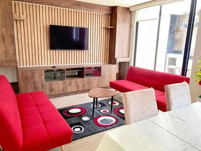 a living room with red furniture and a flat screen tv at Departamento con vistas al mar - Costa Lounge in Lima