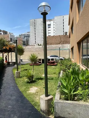 a street light in the grass next to a building at Departamento con vistas al mar - Costa Lounge in Lima