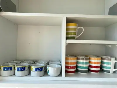 a shelf full of bowls and plates in a cabinet at Departamento con vistas al mar - Costa Lounge in Lima