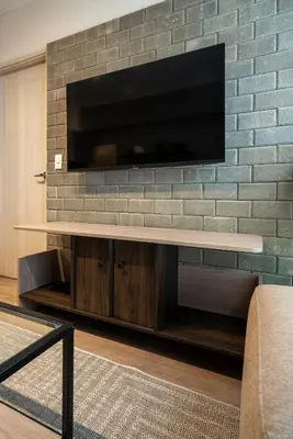 a living room with a tv on a brick wall at S29 by Geko in Lima