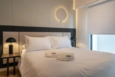 a large white bed with two white pillows on it at S29 by Geko in Lima