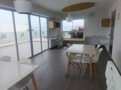 a dining room with a table and chairs and windows at Departamento Costa Verde San M in Lima