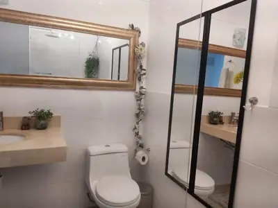 a bathroom with a toilet and a mirror and a sink at Departamento Costa Verde San M in Lima