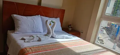 a bed with two swans made out of towels at Haylli Café Oro Hotel in Santa Teresa