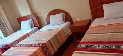 a hotel room with two beds in a room at Haylli Café Oro Hotel in Santa Teresa
