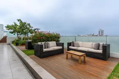 two couches and a coffee table on a balcony at Sunline 2BR by Geko in Lima