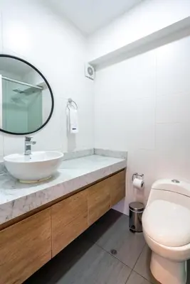 a bathroom with a sink and a toilet and a mirror at Sunline 2BR by Geko in Lima