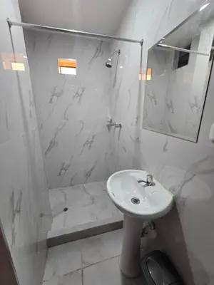 a white bathroom with a sink and a shower at Hostal Prestigio in Lima