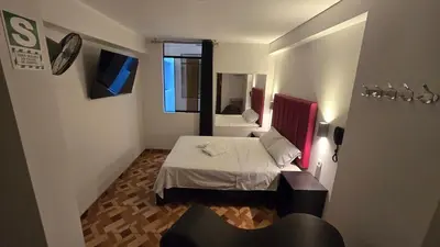 a small room with a bed and a mirror at Hostal Prestigio in Lima