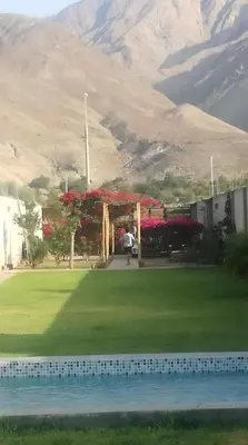 a garden with a pavilion with a mountain in the background at Villa Lunahuana in Lunahuaná