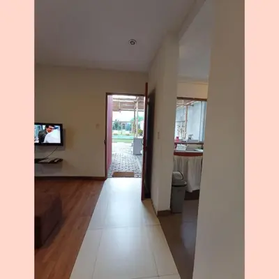 an empty living room with a television and a hallway at Villa Lunahuana in Lunahuaná