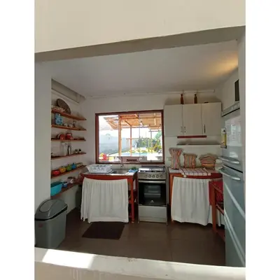 a kitchen with white cabinets and a stove top oven at Villa Lunahuana in Lunahuaná