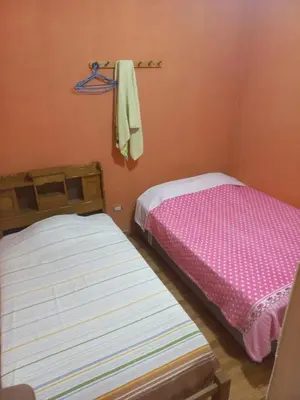 a bedroom with two beds and a towel on a rack at Your home in the city awaits in Lima