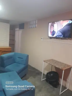 a living room with a blue couch and a tv at Your home in the city awaits in Lima