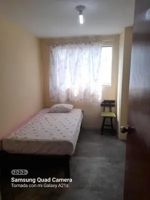 a small bedroom with a bed and a window at Your home in the city awaits in Lima
