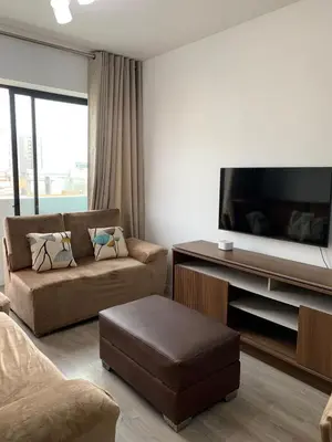 a living room with a couch and a flat screen tv at Departamento céntrico rodeado de áreas verdes in Lima