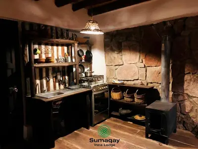 a kitchen with a stove and a stone wall at Sumaqay Lodge -Naturaleza Arte y Arquitectura