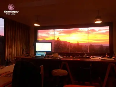 an office with a desk with a computer and a large window at Sumaqay Lodge -Naturaleza Arte y Arquitectura