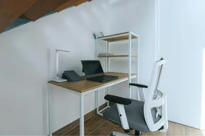 an office with a desk with a laptop and a chair at Tiny House con Piscina Privada, AC and Starlink in Paracas