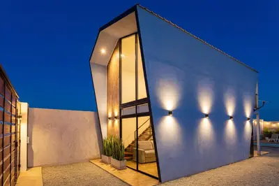 a building with lights on the side of it at Tiny House con Piscina Privada, Jacuzzi, Parrilla y Starlink in Punta Negra
